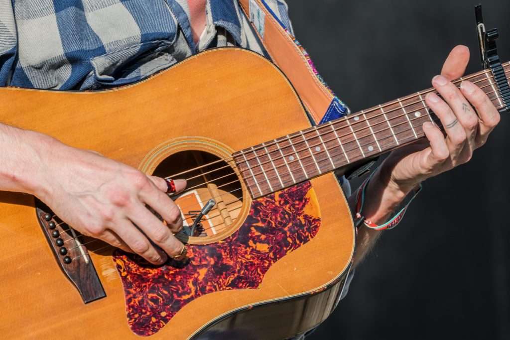 Photograph showing a close-up of the guitarist's hands from the band the Dead Tongues.