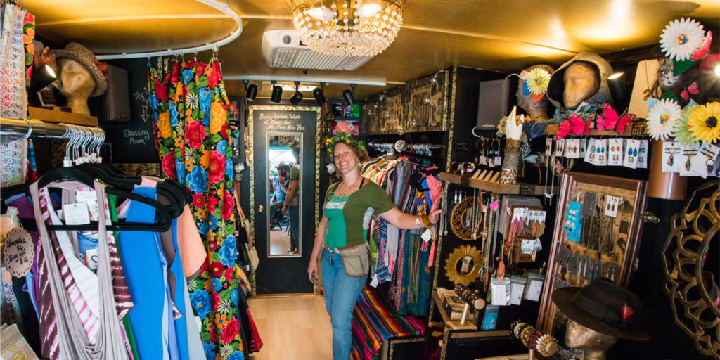 A view inside the ARTeries booth, filled with colorful and unique items. The vendor stands in the middle of the booth.