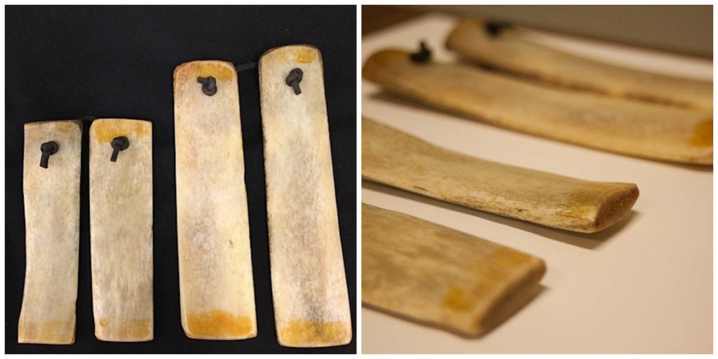 Two views of two sets of bones, made of animal bones. One is larger than the other, and they are each connected by a leather cord.