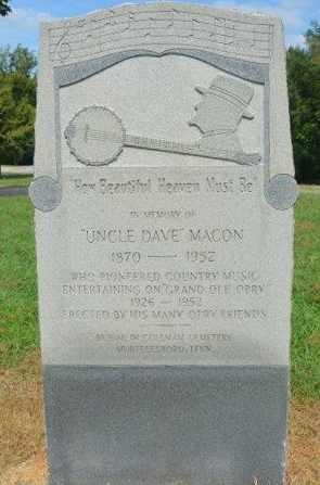 Stone marker to Uncle Dave Macon with his profile and banjo carved at the top and a memorial text to him below.