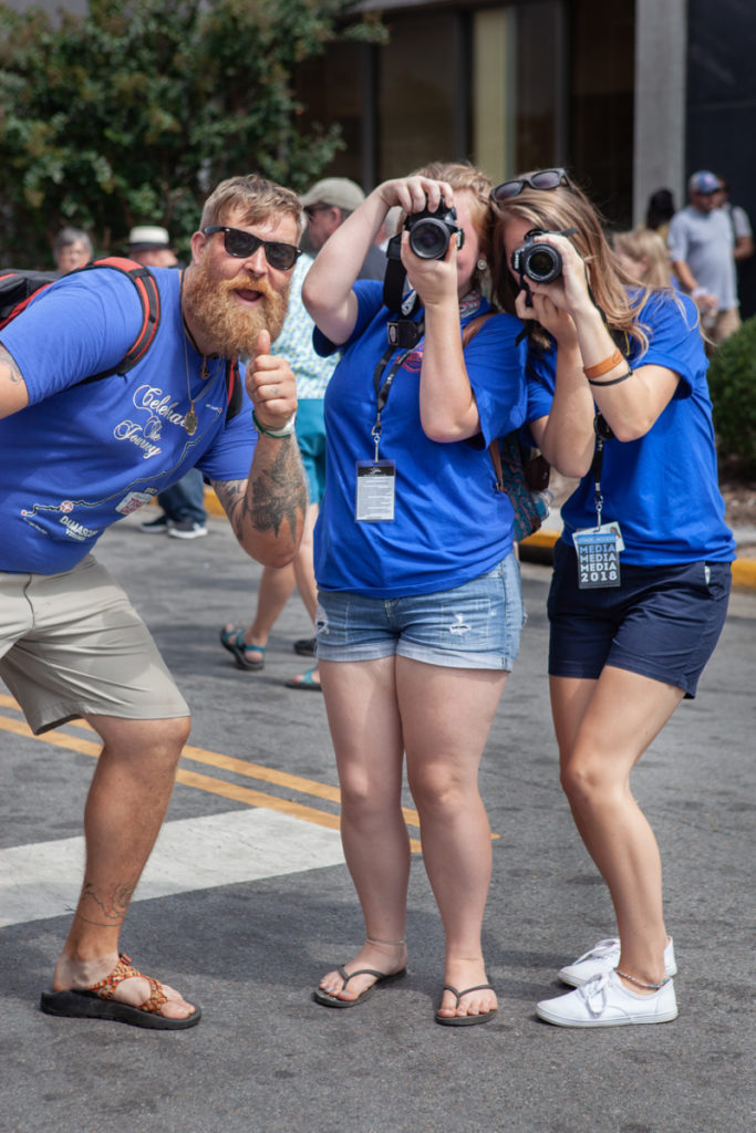 Three student photographers pose and take photos of the photographer!