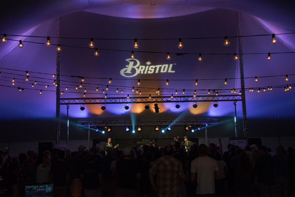7th Street Stage/Dance Tent at night shows off the Bristol logo projected on the ceiling of tent.