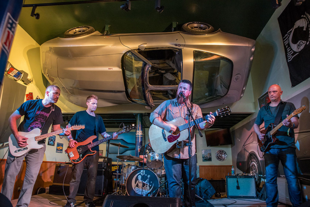 Band performs under Corvette mounted on ceiling at Quaker Steak.