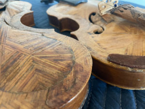 Close ups of the back and front of two matchstick fiddles. You can see the individiual matchsticks placed in a variety of directions to form the bodies of the instruments.