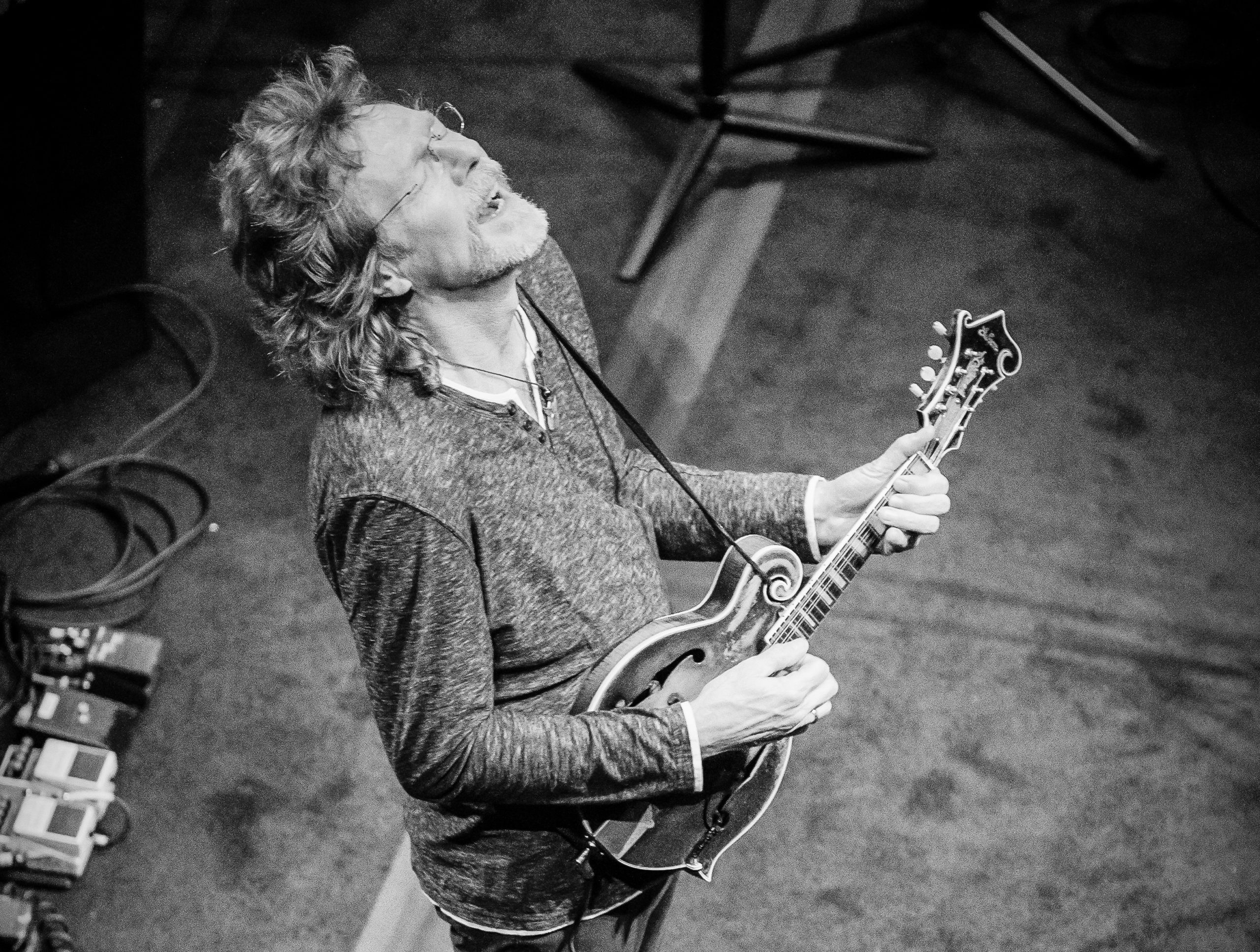 A photo of Sam Bush playing mandolin on stage.