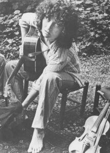 old Photo of Alice Gerrard posing with guitar with no shoes