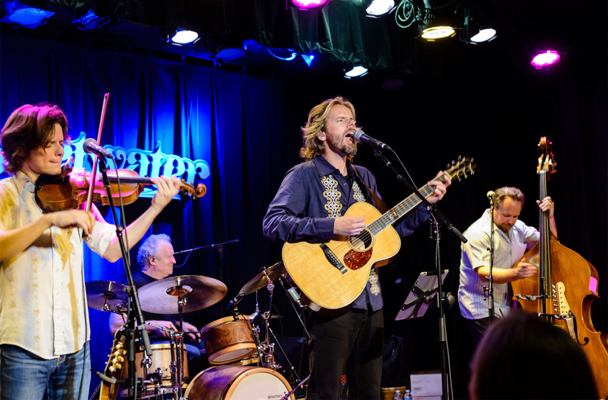 Photo of The Waybacks performing on a stage.