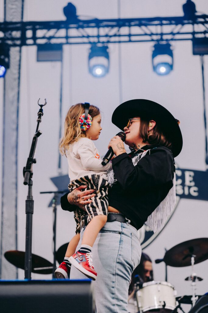 Elle King holding her baby Lucky and singing to him.