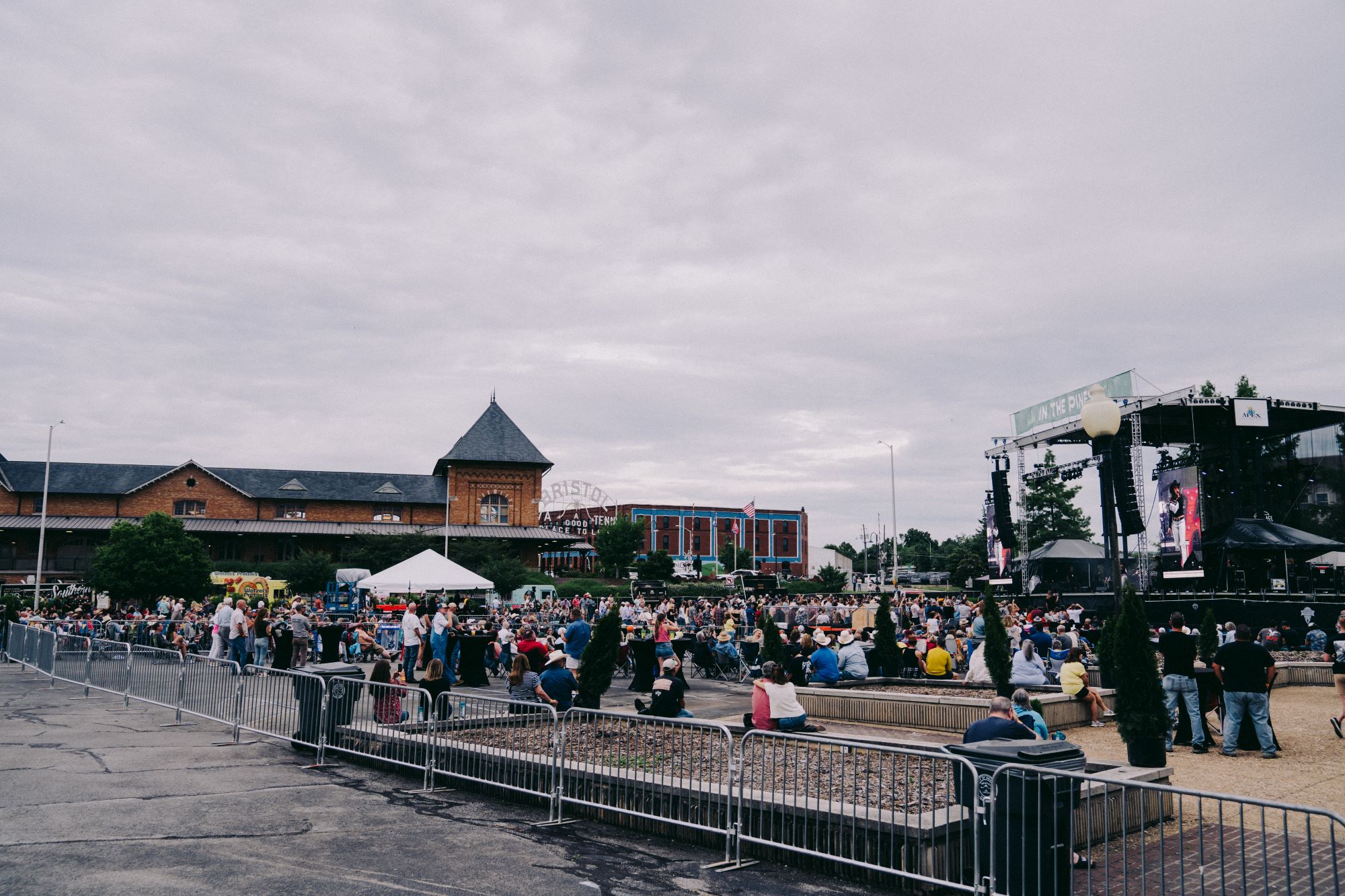 The stage set against the backdrop of the Bristol Train Station, Bristol sign visible in the background, and the audience at In the Pines.